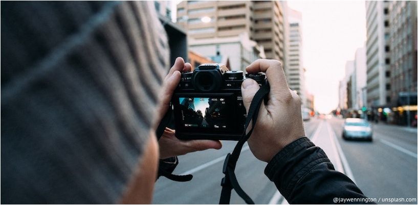 muškarac fotografira gradsku ulicu