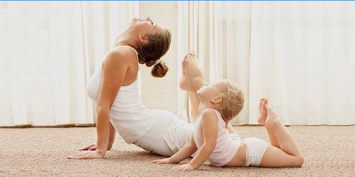 Mama i dijete kod kuće rade jogu.