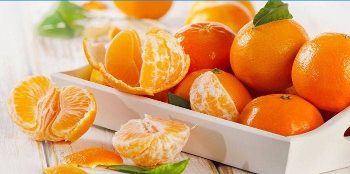 Oguljene i oguljene mandarine na pladnju