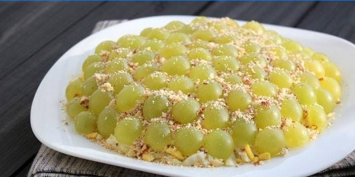 Salata ukrašena bijelim grožđem i pinjolama