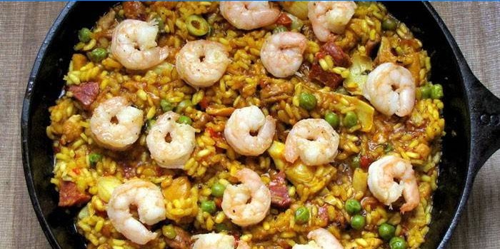 Paella s mesom i kozicama u tavi
