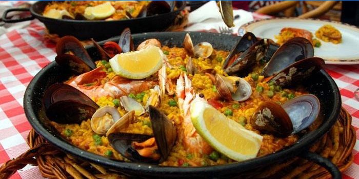 Gotova paella s plodovima mora i limunom u tavi