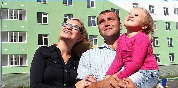 Mlada obitelj na pozadini nove zgrade