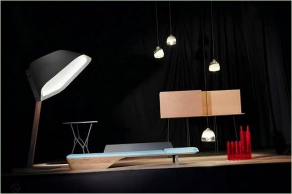 Sastav kućanskih predmeta: stolna svjetiljka, viseće svjetiljke, stol s otvorenim nogama, drveni kauč i radni stol