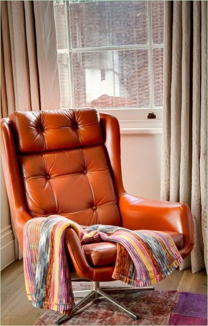 Svijetlo narančasta fotelja u dnevnoj sobi