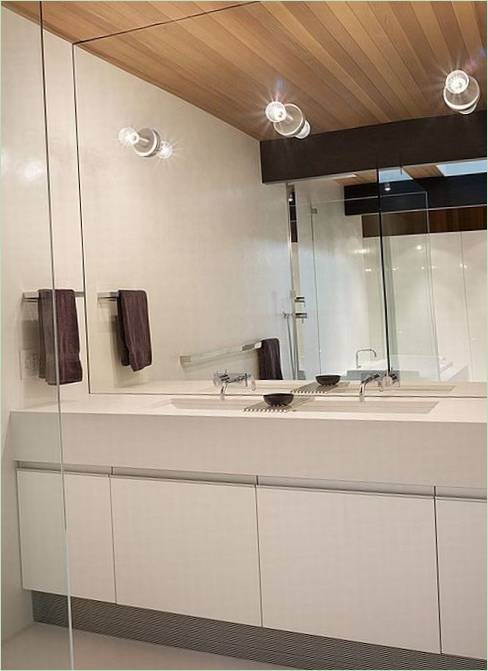 Drveni strop i zrcalni zid u bijeloj unutrašnjosti kupaonice